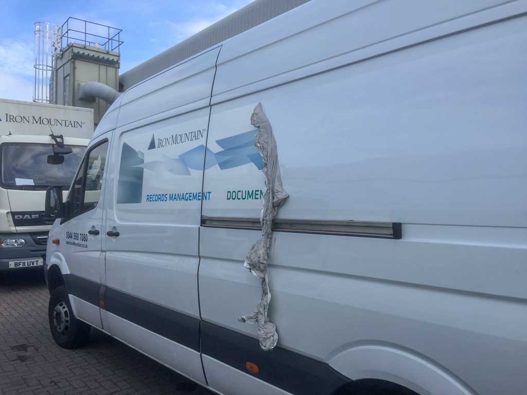 large van with partial wrap in side panel partialy removed and hainging down crumpled